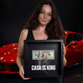 Fiatal nő egy "CASH IS KING" feliratú, dollárköteges képkeretet tart egy piros sportautó előtt.