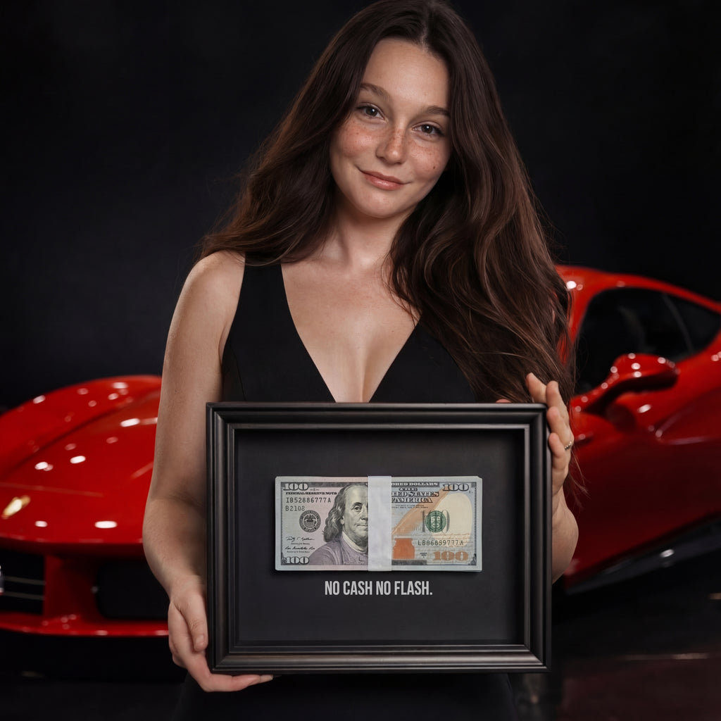 Egy mosolygó, hosszú barna hajú nő egy fekete képkeretet tart maga elé. A keret belsejében fekete alapon egy 3D-s százdolláros köteg és fehér betűkkel a "NO CASH NO FLASH." felirat található. A háttér sötét, de jól kivehető egy mögötte parkoló, elmosódott piros sportautó (Ferrari).